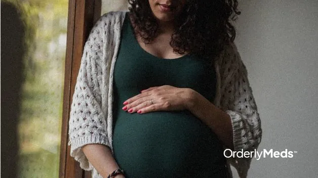 Closeup of a pregnant women with a hand on top of of her stomach